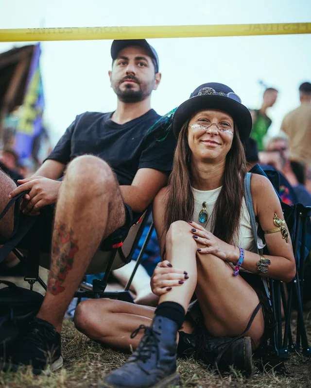 Tony and Salome sitting on the grass at a summer festival